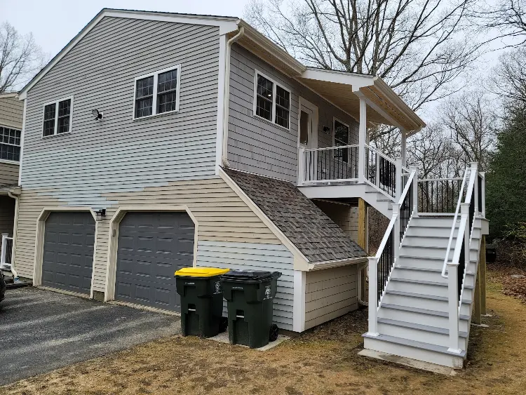 Living space built above a two car garage with a private deck and outdoor stairs by JB Cote Construction